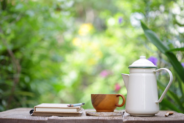 White vintage teapot  and brown cup with notebook