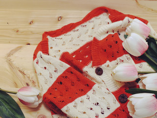 white and orange knit sweater and decoration on wooden background