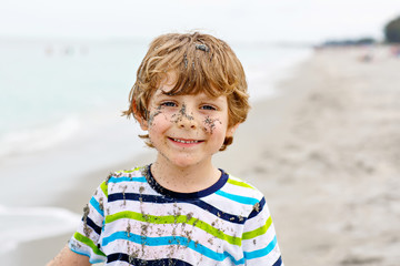 Little kid boy having fun on tropical beach