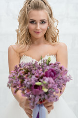 Young bride in studio with exquisite bouquet