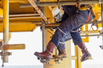The technicians are installing scaffolding to support the work of other maintenance teams platform in sae off shore.