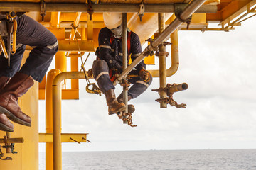 The technicians are installing scaffolding to support the work of other maintenance teams platform in sae off shore.