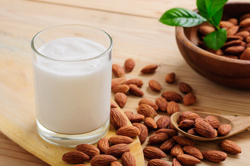 Almond milk with almond on a wooden table - obrazy, fototapety, plakaty