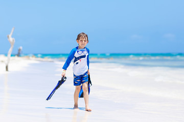 little blond kid boy having fun on tropical beach of Jamaica
