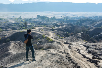 Obraz premium Man on top of Layer Volcanic ash as sand ground of Mount Bromo volcano (Gunung Bromo) at Bromo Tengger Semeru National Park, East Java, Indonesia