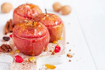 Afwasbaar Fotobehang Dessert Red baked apples with cinnamon, walnuts and honey on a white background. Autumn or winter dessert