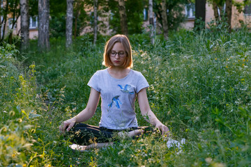 Girl meditating in city park