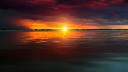 Sunset sky at the lake under the red cloud.