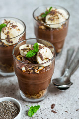 Chocolate pudding with chia and banana in glasses. Healthy dessert or breakfast.