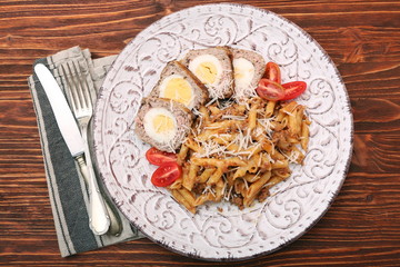 Boiled eggs in a layer of sausage meat wrapped with pasta