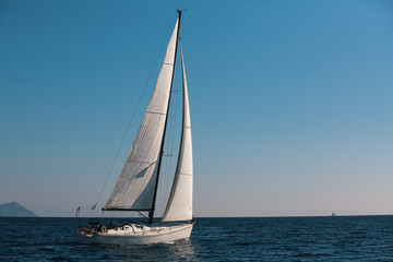 Fototapeta na wymiar Sailing in the wind through the waves at the Sea. Sailors luxury yacht boat in the Aegean.