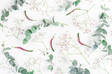 Flowers composition. Abstract pattern made of pink gypsophila flowers and eucalyptus branches on white background. Flat lay, top view