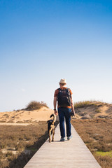 Outdoors lifestyle image of travelling man with cute dog. Tourism concept.