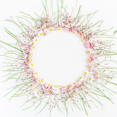 Flowers composition. Floral wreath made of pink gypsophila flowers and daisy flowers on white wooden background. Flat lay, top view, copy space