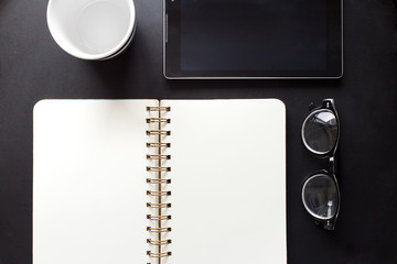 Coffee notebook and glass on wooden table