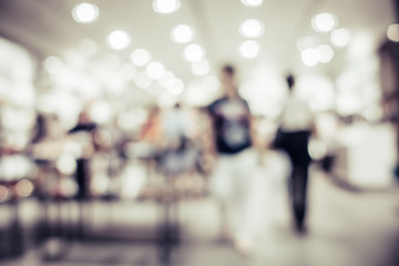 Blurred background of shopping mall corridor with people walking with vintage tone image.