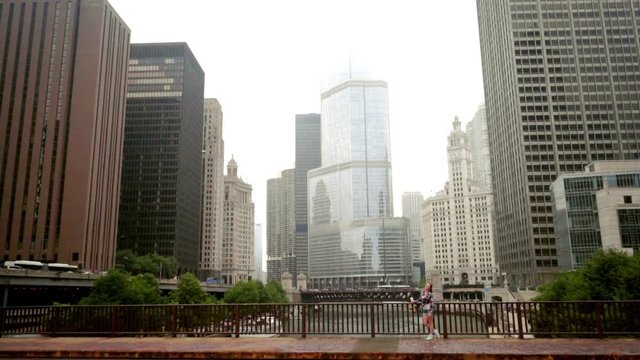 Cityscape. Brunette woman standing on chicago river bridge. Chicago skyline. Beautiful woman standing city river bridge. Modern cityscape. City buildings
