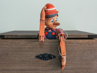 Traditional puppets made of wood.Emerging from the cabinet drawe