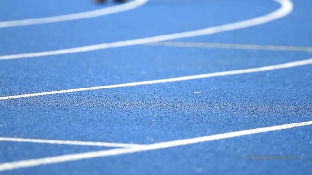Athlete running on the blue track stadium