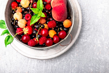 Mix fruit and berries in grey metal bowl. Top view.