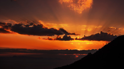 Sub rise behind dark cloud over the mounten
