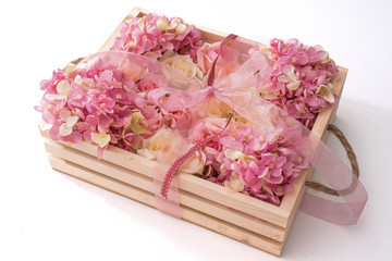 pink ribbon and pink flowers in wooden box