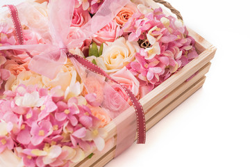 pink ribbon and pink flowers in wooden box