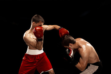 Naklejka na ściany i meble Two professional boxer boxing on black smoky background,