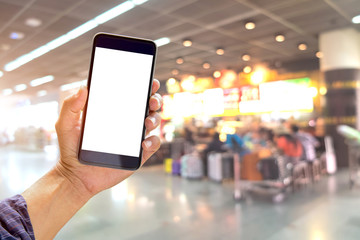 Man holding and using smartphone at check in terminal airport background. Blank screen mobile phone for graphic display montage.