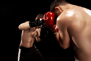 Two professional boxer boxing on black background,