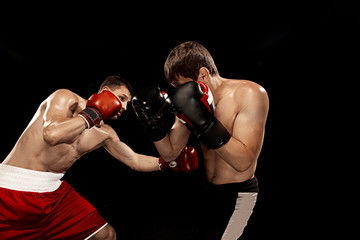 Two professional boxer boxing on black background,