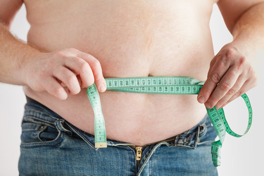 Fat man belly with measuring tape. Lose weight concept.