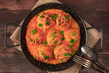 Pan of meatballs in tomato sauce, overhead photo with copyspace
