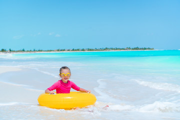 Adorable little girl with inflatable rubber circle splashing. Kid having fun on summer active vacation