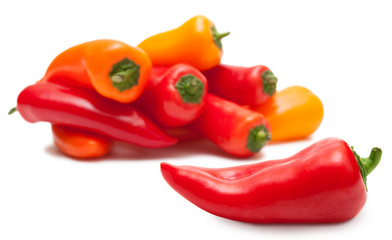 Perfect red paprika and heap of peppers over white