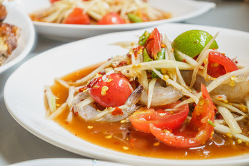 papaya salad with fresh shrimp on white plate, spicy salad of thailand