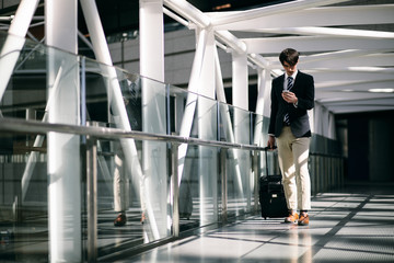 Obraz premium young man carrying a carry bag with him on passage of modern building