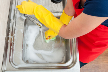 Fototapeta premium Female housekeeper cleaning the kitchen sink