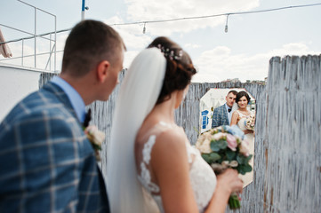 Fantastic bride and handsome groom looking in the mirror on their wedding day.