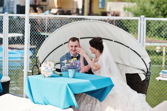 Beautiful wedding couple enjoying each other's comany on a bench on a lakeside.