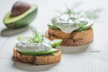 Closeup of sandwich with avocado, dill and tzatziki sauce