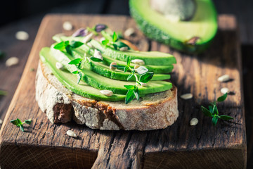 Closeup of sandwich with avocado, seeds and herbs