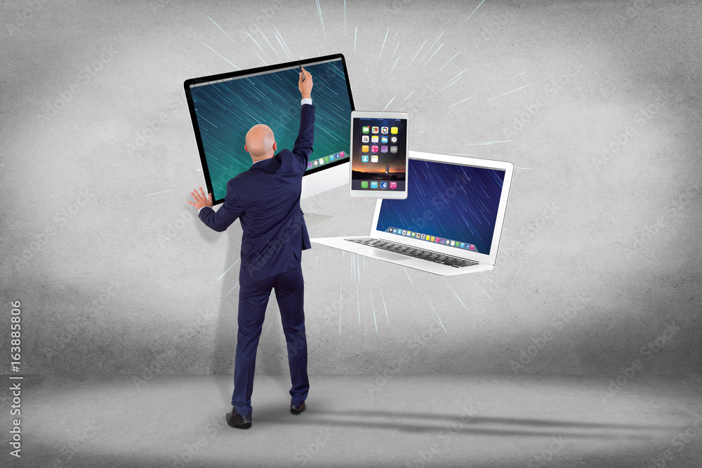 Poster businessman in front of a wall with computer and devices displayed on a futuristic interface - multi