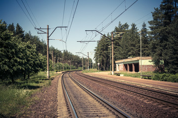 Fototapeta na wymiar railroad tracks near an old small railroad station, transportation background