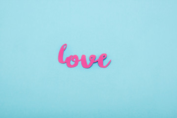 Fototapeta na wymiar Top view of decorative pink love symbol isolated on blue background