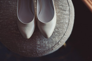 Bride wedding shoes with high heels and silver brilliant earrings on sheep's clothing