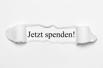 Jetzt spenden! auf weißen gerissenen Papier