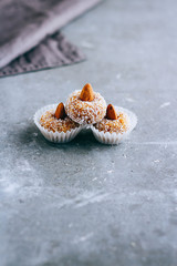 Natural useful raw sweets from dried apricots, with almonds in coconut shavings