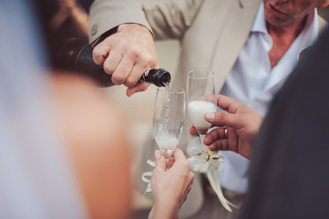 The waiter pours champagne in crystal glasses