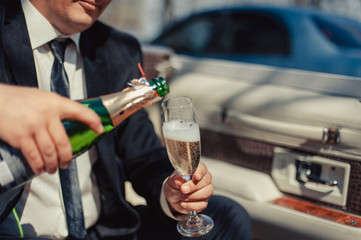 The waiter pours champagne in crystal glasses
